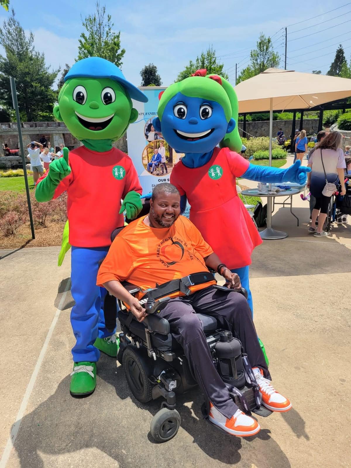 Lamont at an outdoor Agape gathering with two costumed characters