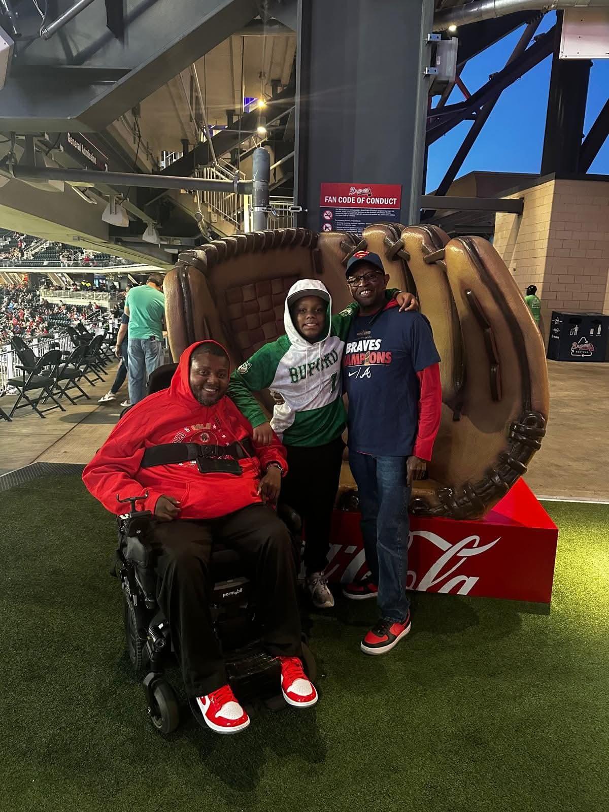 Lamont with two people at a baseball stadium