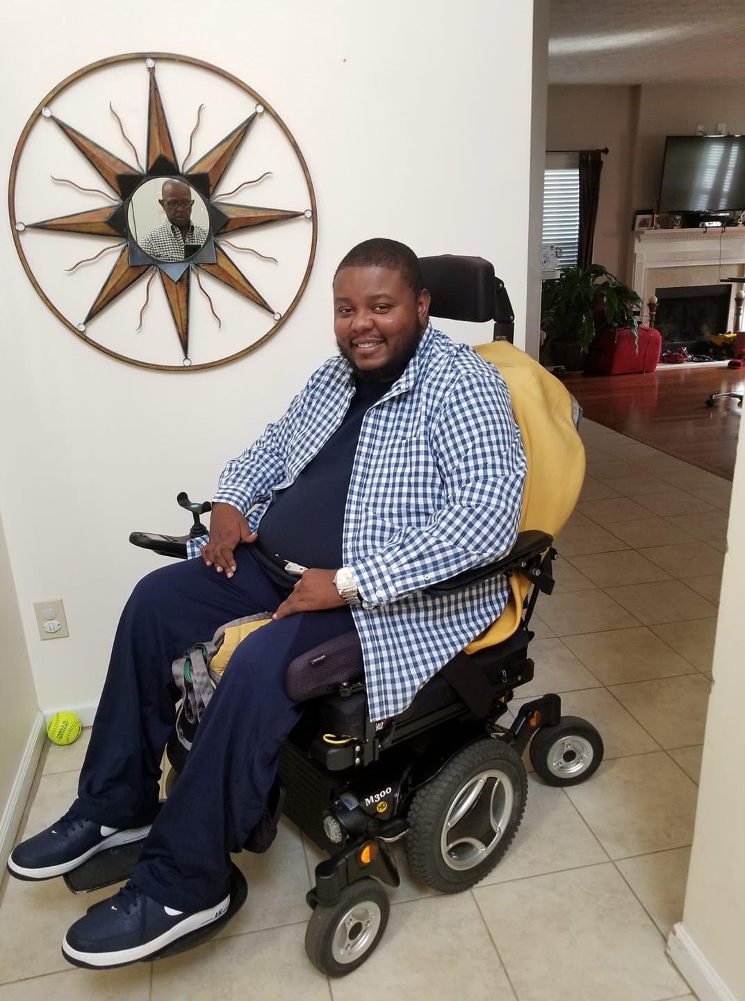 Lamont seated at home in his power wheelchair